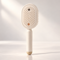 Glowmane electric spa massage comb on a neutral beige backdrop